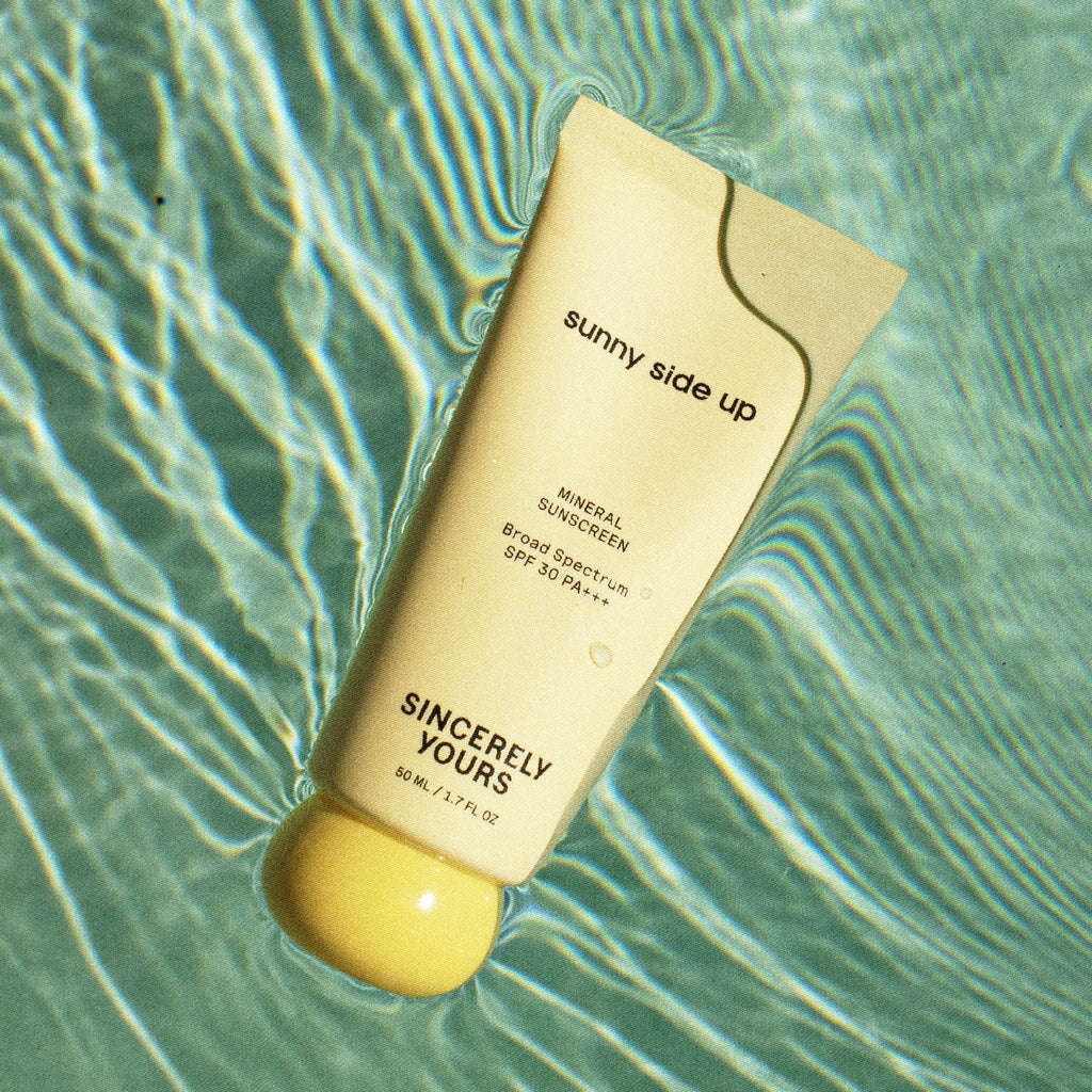 Sunscreen bottle labeled 'sunny side up' on a water surface